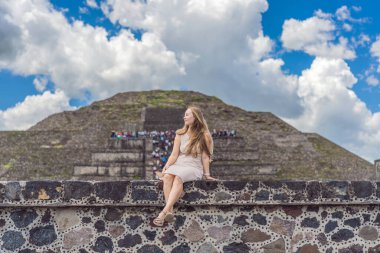 Meksika 'da Teotihuacan piramitlerinin önünde duran kadın turist gezinin, maceranın ve kültürel mirasın tadını çıkarıyor. Seyahat, turizm ve keşif konsepti.