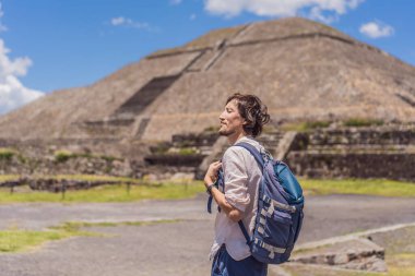 Meksika 'da Teotihuacan Piramitleri önünde poz veren erkek turist, gezinin, kültür mirasının ve seyahat macerasının tadını çıkarıyor..