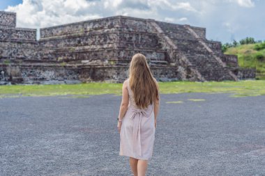 Meksika 'da Teotihuacan piramitlerinin önünde duran kadın turist gezinin, maceranın ve kültürel mirasın tadını çıkarıyor. Seyahat, turizm ve keşif konsepti.