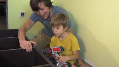 Baba ve oğul, elektrikli tornavidayla büyük bir kitaplık kuruyorlar. Ev gelişiminde baba-oğul bağları, öğrenme araçları ve takım çalışması kavramı.