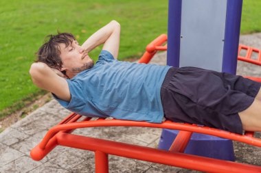 Şehir parkında egzersiz yapan, güneşli bir günde açık havada esneme ve antrenman yapan, aktif yaşam tarzı, sağlık, motivasyon ve günlük vücut bakımı kavramı doğal gerçek bir çevrede..