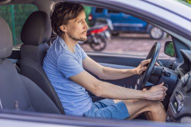 Adam arabasını şehir merkezine park ediyor. Dar bir alanda dikkatlice manevra yapıyor. Sürücü kavramı, araç kontrolü, günlük seyahat, güvenli park yeri ve modern yaşam tarzı..