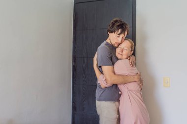 Erkek ve kadın ön kapıda kucaklaşıyorlar, ayrılmadan önce duygusal bir anı paylaşıyorlar. Aşk kavramı, bağlantı, elveda, ilişkiler ve günlük mahrem insan duyguları..