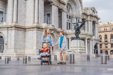 İki oğlu ile birlikte Mexico City 'deki Palacio de Bellas Artes' in önünde aile seyahatinin, mimarinin ve kültürel mirasının tadını çıkaran bir anne turist. Aile seyahati ve bağlanma kavramı.