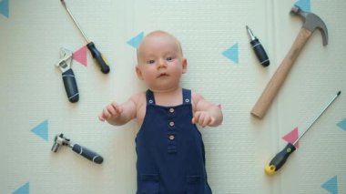 Oyuncak aletlerle çevrili mekanik kostümlü sevimli bir bebek. Tamir kavramı, yaratıcı oyun ve çocukları eğlence yoluyla tamir ve problem çözme dünyasıyla tanıştırmak..
