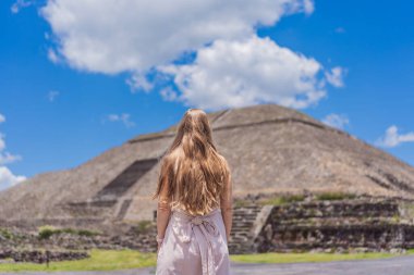 Meksika 'da Teotihuacan piramitlerinin önünde duran kadın turist gezinin, maceranın ve kültürel mirasın tadını çıkarıyor. Seyahat, turizm ve keşif konsepti.