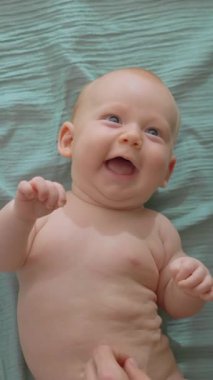 Mutlu baba 3 aylık oğlunu bir yatakta yatarken gıdıklıyor, kahkaha, neşe ve şefkat yaratıyor. Ebeveynlik, sevgi, babalık ve aile mutluluğu konsepti..