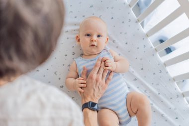 Baba bebeğini nazikçe evdeki bir beşiğe yerleştiriyor, sakin ve güvenli bir uyku zamanı yaratıyor. Babalığı önemseme sahnesi güven ve sıcaklıkla dolu. Ebeveynlik, bebek uykusu ve aile bağları.