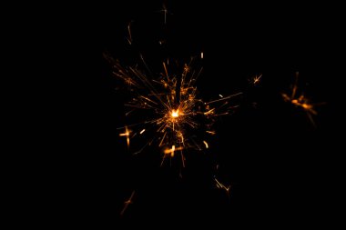 Noel reklamı. Noel ışıldıyor. Yangın arka planda parlıyor. Siyah arka planda izole edilmiş altın ateş parıltısı. Siyah arka planda yeni yıl kıvılcımı. Işık efekti parlıyor