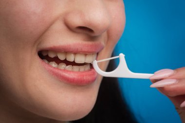 Diş sağlığı kliniği. Diş ve stomatoloji konsepti. Diş hijyeni ve ağız sağlığı konsepti. Diş ipiyle plastik kürdan kullanarak diş fırçalamak. Hijyen ve ağız boşluğu kavramı