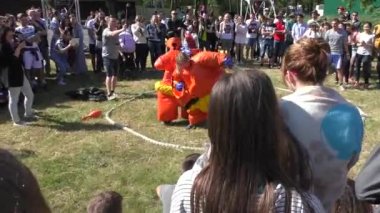 Komik turuncu Sumo güreşçisi kostümler giymiş kız güneşli bir yaz günde güreş