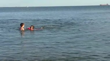 İki küçük çocuğu denizde yaz tatili oynuyorlar