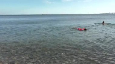 Küçük çocuk giyinmiş turuncu şişme kollu, Snorkling olduğunu