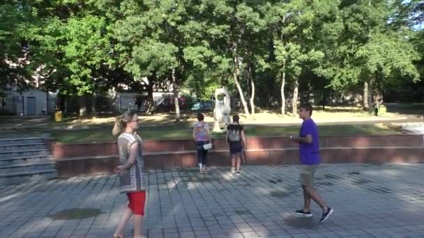 Three Girl and Man are Strolling in Park in the Day of Summer, Posing Around a Monument — стоковое видео
