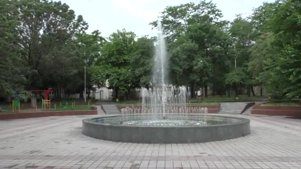 Runda fontän i molniga vädret nära lekplats i parken — Stockvideo