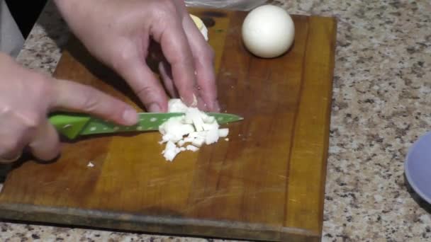 Dames handen hakken eieren voor salade aan boord — Stockvideo