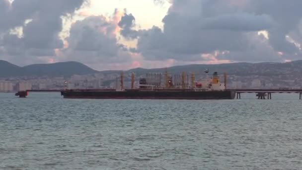 Chiatta galleggiante in mare aperto, non lontano dalla costa con piccola città — Video Stock