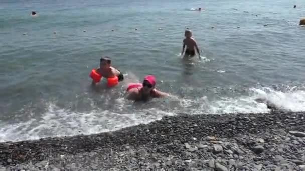 Mãe com dois filhos relaxando na praia no dia de verão — Vídeo de Stock