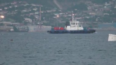 Küçük şehir aydınlatılmış sahil boyunca yüzen küçük beyaz gemi