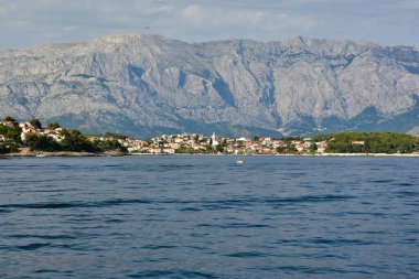Brac adasındaki Sumartin köyü arka planda Biokovo sıradağlarıyla denizden izlendi, Hırvatistan