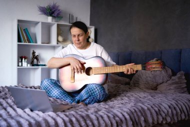       Son sınıf öğrencisi kadın online derslerle gitar çalmayı öğreniyor.                         