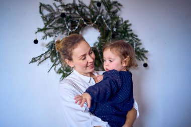   Anne ve bebek çelengi dekore ediyor, Noel ağacı ev dekorasyonu için.                             