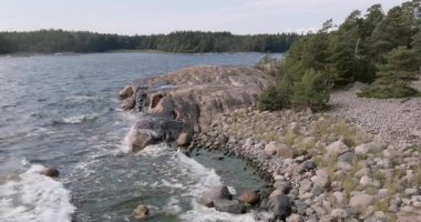 Pirttisaari Doğa Koruma Alanı 'nda kayalık sahile vuran dalgaların hava görüntüsü, güneşli yaz havasında, Pirttisaari, Porvoo, Finlandiya.