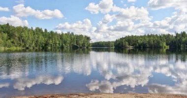 Yazın gökyüzündeki bulutların yansımasıyla Fisktrask Gölü 'nün dalgalanma görüntüsü, Sipoonkorpi Ulusal Parkı, Finlandiya.