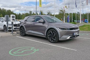 Laajalahti, Finlandiya - 19 Ağustos. 2025: Hyundai Ioniq 5 EV (2022) alışveriş merkezinin park yerine park edilmiş elektrikli araba elektrik yükleme istasyonu.