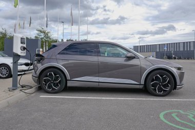 Laajalahti, Finlandiya - 19 Ağustos. 2025: Hyundai Ioniq 5 EV (2022) alışveriş merkezinin park yerine park edilmiş elektrikli araba elektrik yükleme istasyonu.