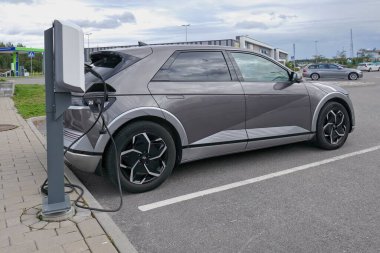 Laajalahti, Finlandiya - 19 Ağustos. 2025: Hyundai Ioniq 5 EV (2022) alışveriş merkezinin park yerine park edilmiş elektrikli araba elektrik yükleme istasyonu.