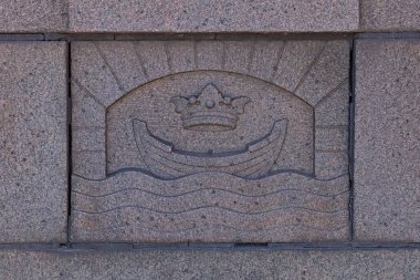 Taş oymacılığı Pitkasilta (Uzun Köprü) granit köprüsünden bir ayrıntıdır, Helsinki şehrinin arması Finlandiya 'nın başkenti Helsinki' deki köprünün korkuluklarında taşa oyulmuştur..