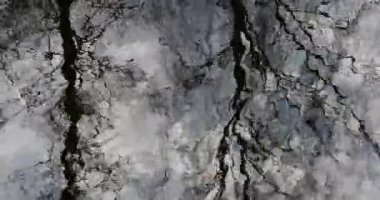 Bahar aylarında hafif dalgalı su yüzeyinde çıplak ağaçların ve açık gökyüzünün soyut yansımaları, Mustavuori, Helsinki, Finlandiya.