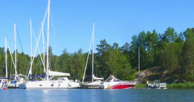 Inkoo, Finlandiya - 9 Temmuz. 2025: Güneşli yaz havasında Elisaari adasına yolcu almak için küçük bir feribot geliyor.