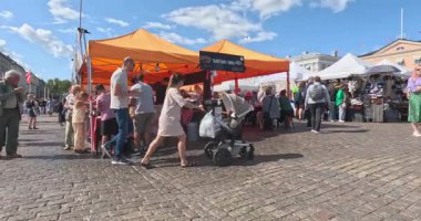 Helsinki, Finlandiya - 13 Ağustos. 2025: Pazar Meydanı (Fince 'de Kauppatori olarak bilinir), satıcıların yaz aylarında yiyecek sattığı kalabalık bir merkez meydan..