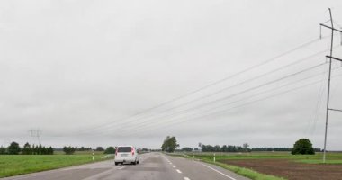 Ilmatsalu, Estonya, Avrupa - 13 Eylül. 2025: Bulutlu sonbahar havasında Tartu 'dan Viljandi' ye giden yol boyunca POV kurutma.