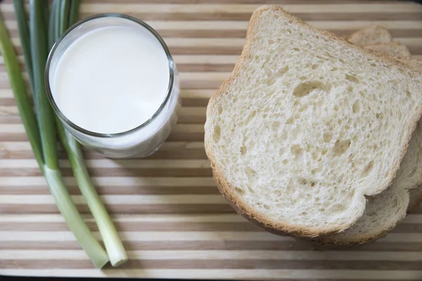 Brotstücke und grüne Zwiebeln am Stand — Stockfoto