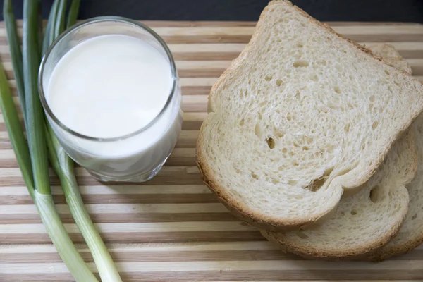 Darab kenyeret és zöld hagymával, az állvány — Stock Fotó
