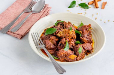 Indian Lamb Masala/Mutton Masala Garnished with Onion, Curry Leaves and Hot Chili Peppers 