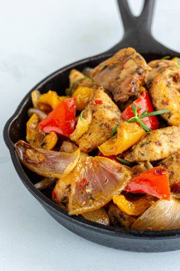 Bir tencere fırında tavuk ve sebzeler dökme demiri yakın çekim fotoğrafında.