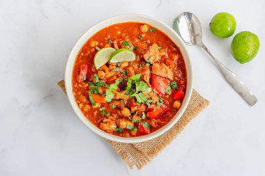 Baharatlı domates soslu nohut ve sebzeli Fas tavuk güveci.