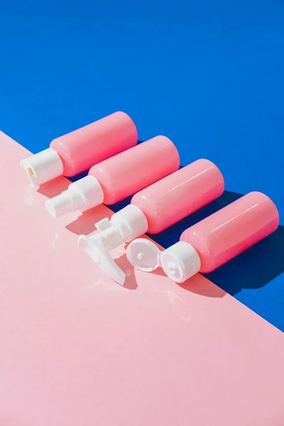 Monochrome cosmetic creams for face in blank bottles on pink and blue background. Isometric pop art style. Bio organic product.