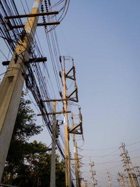 Yüksek voltajlı elektrik hatları ve temiz gökyüzünün altında iletişim kabloları olan elektrik direkleri. Altyapı ve kentsel temalar için mükemmel.