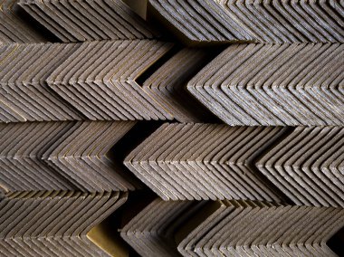 Yığılmış karton köşeli koruyucuların zigzag geometrik desenli soyut arkaplanı. Tasarım, ambalaj ve endüstriyel temalar için mükemmel.