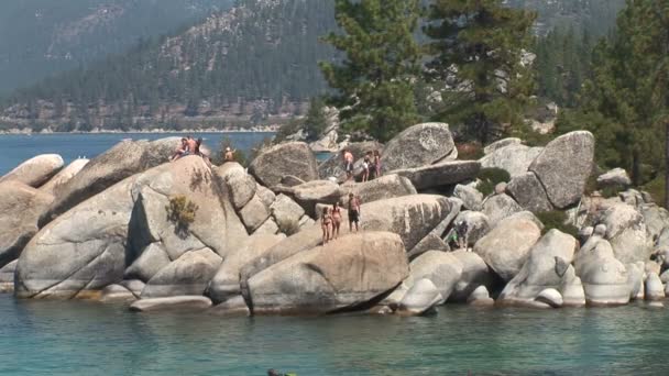 Gente en las rocas en el lago Tahoe — Vídeo de stock