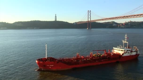 Vrachtschip undern Lissabon Golden Gate Bridge — Stockvideo