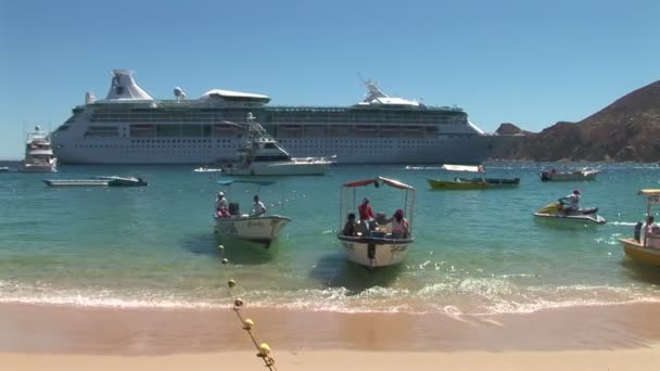 Wassertaxis am Strand mit Kreuzfahrtschiff im Meer — Stockvideo