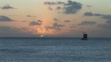 Gün batımında okyanusta yelkenli