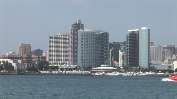 Bogserbåt simma i havet och San Diego skyline — Stockvideo