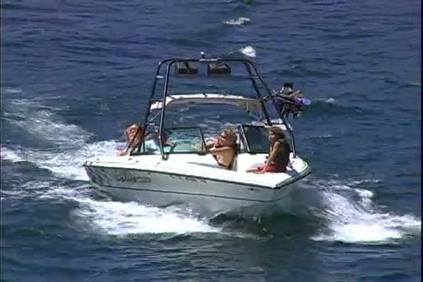 Barco con gente nada en el lago — Vídeos de Stock